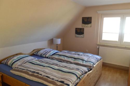 uma cama com um cobertor num quarto em Ferienhaus Stana em Leer