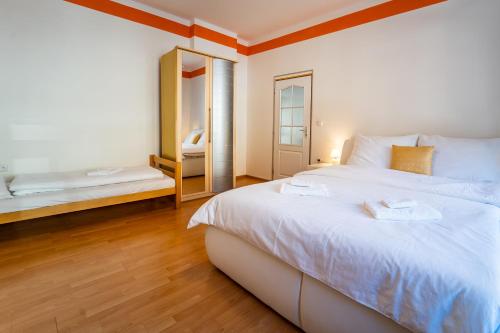 a bedroom with a large white bed and a mirror at Tuan Long Apartments in Jáchymov