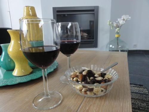 two glasses of wine and a bowl of food on a table at B&B Appartementen Engelenhof in Stevensweert