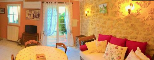ein Wohnzimmer mit einem Sofa, einem Tisch und einem Fenster in der Unterkunft le vieux pont in Carpentras