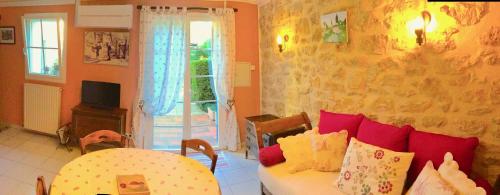 a living room with a couch and a table and a window at le vieux pont in Carpentras