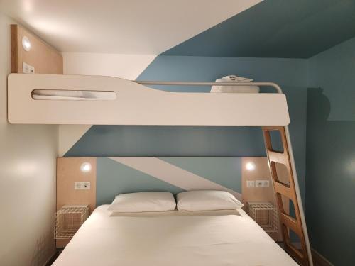 a small bedroom with a bunk bed with white sheets at ibis budget Chambourcy Saint Germain in Chambourcy