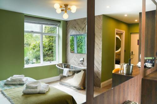 baño con bañera, lavabo y ventana en Draycote Hotel And Whitefields Golf Course, en Rugby