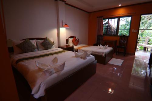 Habitación de hotel con 2 camas y ventana en Coconut House Resort en Koh Samui