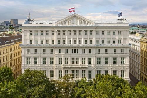 a white building with a flag on top of it at Hotel Imperial, a Luxury Collection Hotel, Vienna in Vienna