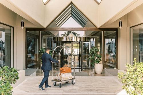 a man pushing a cart with a dog in it at Sheraton Rhodes Resort in Ixia