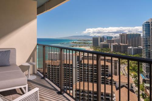 a balcony with a view of the beach and ocean at Sheraton Waikiki Beach Resort in Honolulu