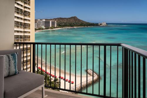 a balcony with a view of a beach and the ocean at Sheraton Waikiki Beach Resort in Honolulu