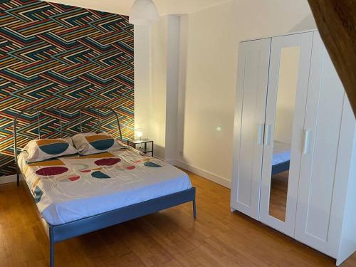 um quarto com uma cama com um padrão na parede em Gite Le Baulois, maisonnette calme et confort en vallée de Loire em Baule