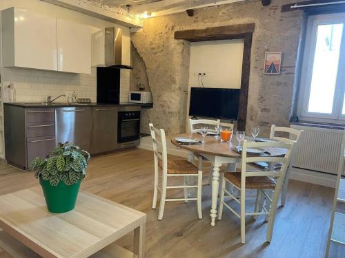 uma cozinha e sala de jantar com mesa e cadeiras em Gite Le Baulois, maisonnette calme et confort en vallée de Loire em Baule