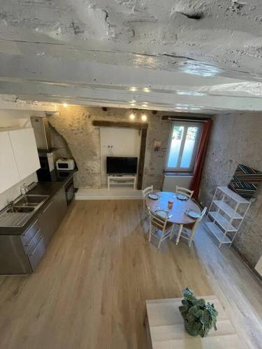 une cuisine et une salle à manger avec une table dans une pièce dans l'établissement Gite Le Baulois, maisonnette calme et confort en vallée de Loire, à Baule