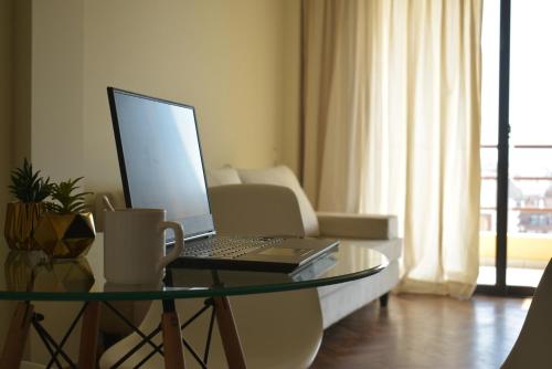 a laptop computer sitting on a glass table in a living room at Departamento en Nueva Córdoba in Cordoba
