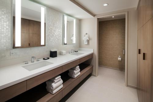 a bathroom with two sinks and a large mirror at Sheraton Waikiki Beach Resort in Honolulu
