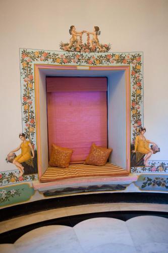 a bed with two men sitting on top of it at Shiv Niwas Palace by HRH Group of Hotels in Udaipur