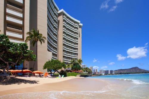a beach in front of a hotel and the ocean at Sheraton Waikiki Beach Resort in Honolulu