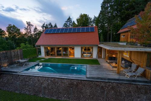 a home with a pool and a house with a red roof at Stadl Niglberg Südsteiermark in Sankt Johann im Saggautal