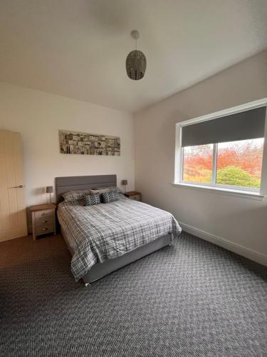 a bedroom with a bed and a large window at Old Schoolhouse in Lairg