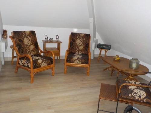 a living room with two chairs and a table at CHARMANT APPARTEMENT DANS MAISON DE CARACTERE in Saint-Brice-sur-Vienne