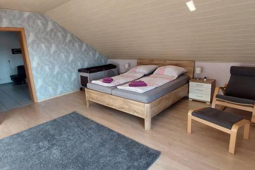 a bedroom with a bed and a chair at Große tolle 4 Zimmer Ferienwohnung im Herzen des Odenwaldes in Mörlenbach
