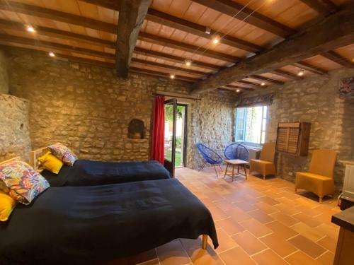a bedroom with a bed and a stone wall at A l’ombre du Tilleul in Crestet