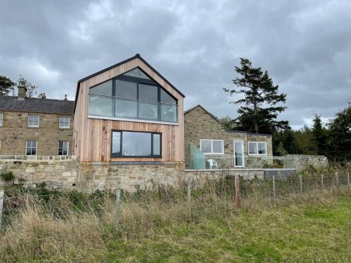 a wooden house on top of a stone wall at The Coach House in Alnwick