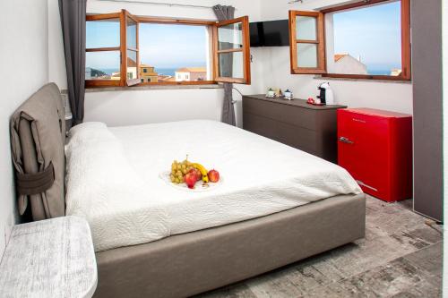 Un dormitorio con una cama con un plato de fruta. en Romeo and Juliet Affittacamere, en Santa Teresa Gallura