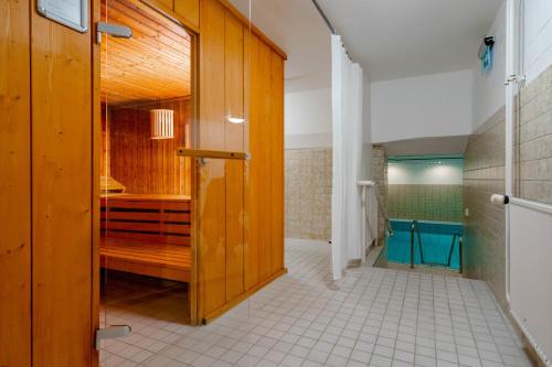 een badkamer met een houten deur en een tegelvloer bij Ferienwohnung Neptun in Westerland