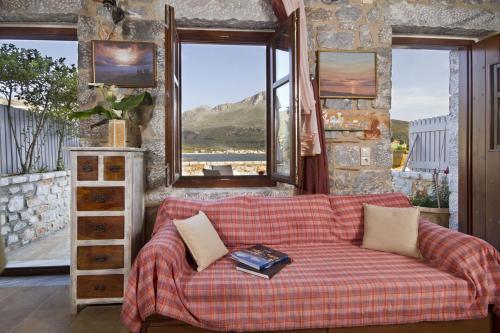 a living room with a couch and a window at Elixirion Guest House in Karavostasion