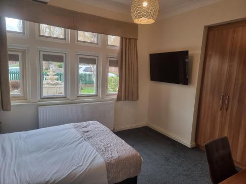 Schlafzimmer mit einem Bett und einem Flachbild-TV in der Unterkunft DORSET ARMS HOTEL in Newcastle upon Tyne