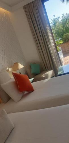 a white couch with red pillows sitting next to a window at Marina Smir Hotel & Spa in M'diq