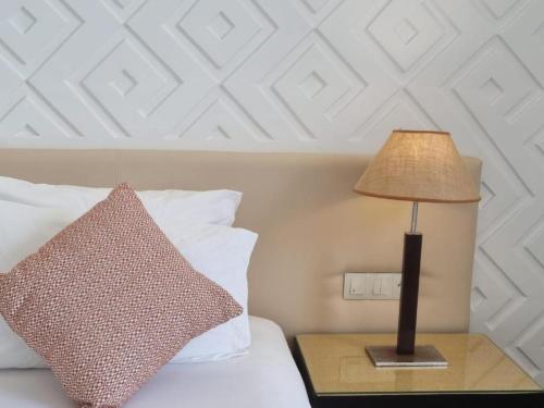 a lamp on a night stand next to a bed at Marina Smir Hotel & Spa in M'diq
