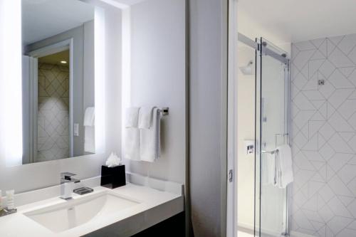 a white bathroom with a sink and a shower at Long Beach Marriott in Long Beach