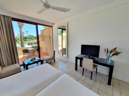 a bedroom with a bed and a desk with a television at Marina Smir Hotel & Spa in M'diq