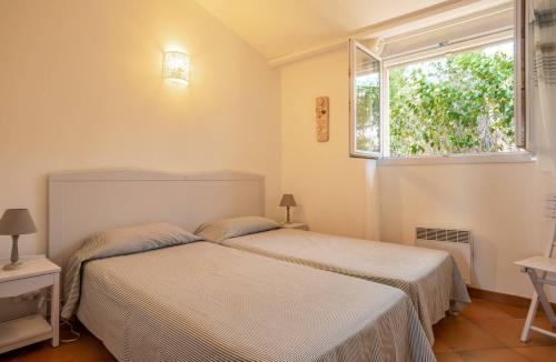 un dormitorio con una cama y una ventana en Les Hauts de Pavellone, en Porto Vecchio