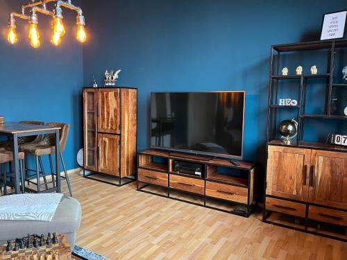 a living room with a large television and a table at Ferienwohnung "Charlotte" nahe der Elbe mit kostenlosem Parkplatz vor der Tür in Magdeburg