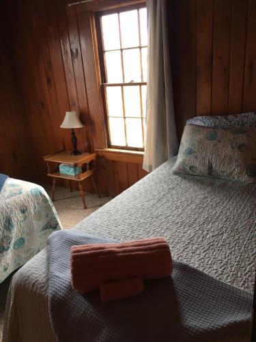 a bedroom with a bed and a window at Calico Jack's Galley cottage in Kitty Hawk