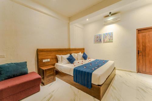 a bedroom with a bed and a red couch at Kapaliya Unawatuna in Unawatuna