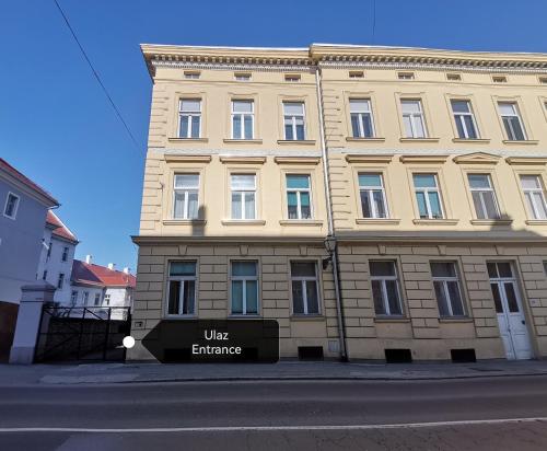 a large building with a sign in front of it at The Gate rooms in Novi Sad