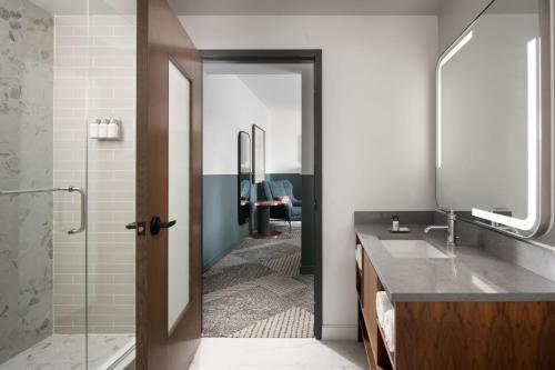a bathroom with a shower and a sink and a mirror at Hotel Forty Five, Macon, a Tribute Portfolio Hotel in Macon