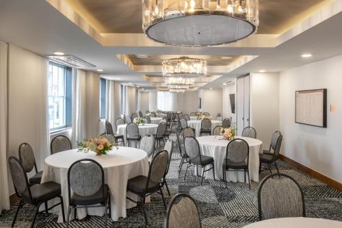 einen Konferenzraum mit Tischen, Stühlen und einem Kronleuchter in der Unterkunft Hotel Forty Five, Macon, a Tribute Portfolio Hotel in Macon