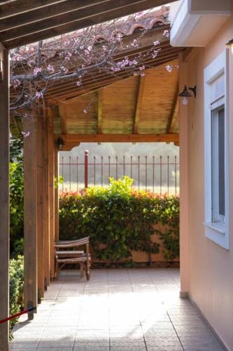 a patio with a bench and a fence and flowers at Phoceus Poolfront Grande Villa in Palaiá Fókaia
