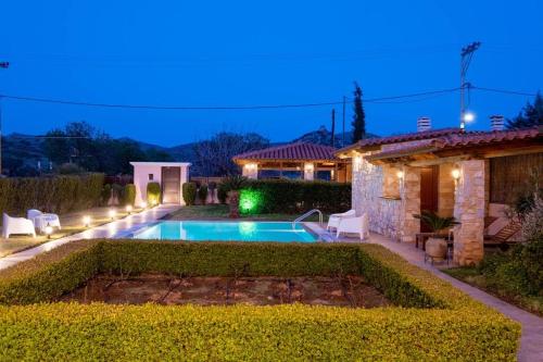 a backyard with a swimming pool and a house at Phoceus Poolfront Grande Villa in Palaiá Fókaia
