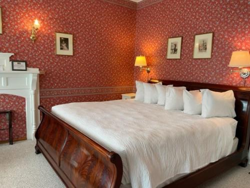 a bedroom with a large bed with red wallpaper at Central House Inn in Bar Harbor