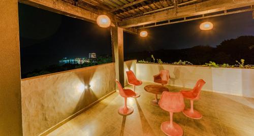 a group of red chairs sitting on a balcony at night at Kapaliya Unawatuna in Unawatuna
