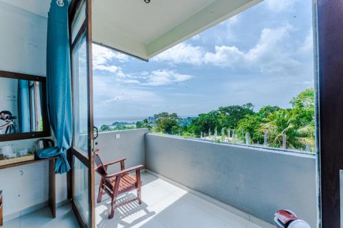 a balcony with a chair and a view of the ocean at Kapaliya Unawatuna in Unawatuna
