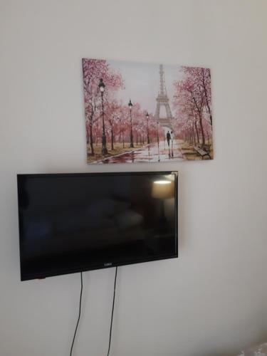 uma televisão de ecrã plano com uma imagem da torre Eiffel em MPOZA APPARTMENTS em Patra