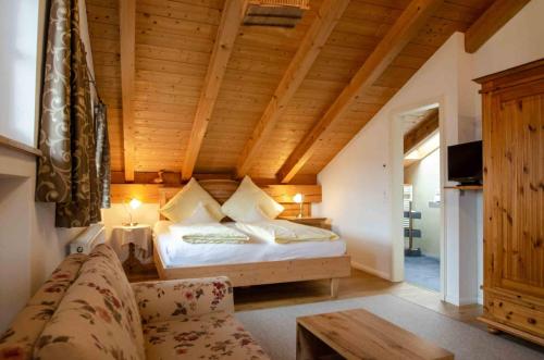 a bedroom with a bed with a wooden ceiling at Hotel Ferienhaus Fux in Oberammergau