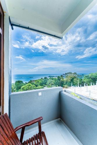 a balcony with two chairs and a view of the ocean at Kapaliya Unawatuna in Unawatuna