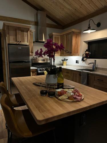 a kitchen with a table with food and wine glasses at Private Off Grid Chalet Nestled in Nature With Waterfront Access Near Algonquin Park in Barrys Bay