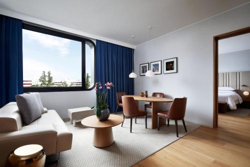 a living room with a couch and a table at Sheraton Milan San Siro in Milan